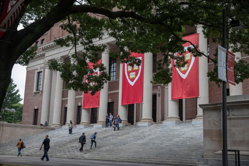 Crimson Harvard banners hanging from Widener Library