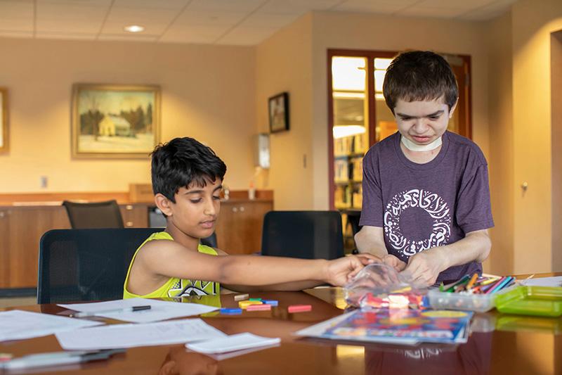 Ben Elwy '23 (right) is teaching Arabic and cultural education to children at the Wellesley Free Library. 
