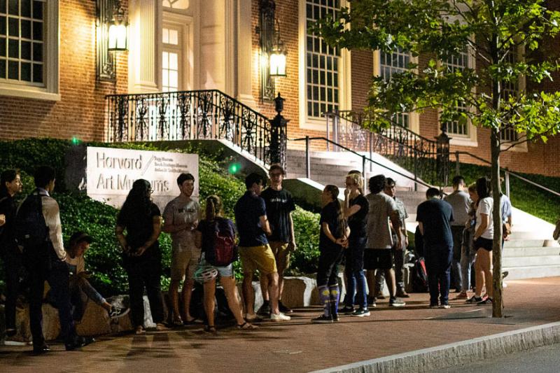 students standing outside at night waiting to get into the Art Museum