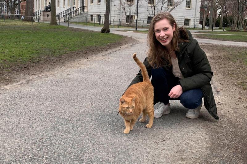 Barbara Oedayrajsingh Varma walks through Harvard Yard with Remy the cat.