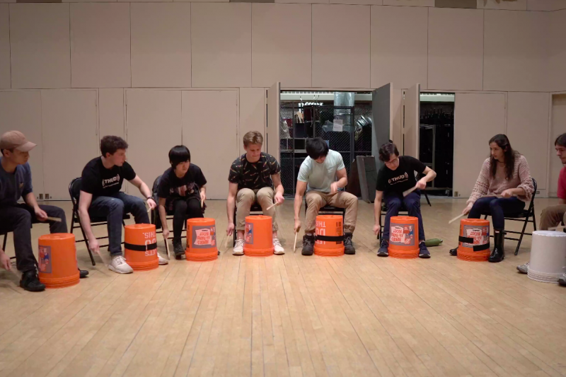 The Harvard Undergraduate Drummers perform a musical number using buckets.