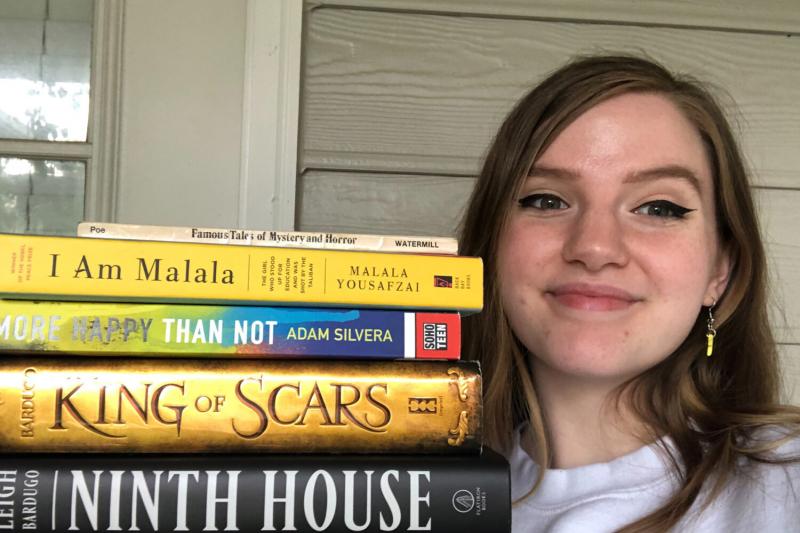 Madi Fabber '22 poses with a stack of novels.