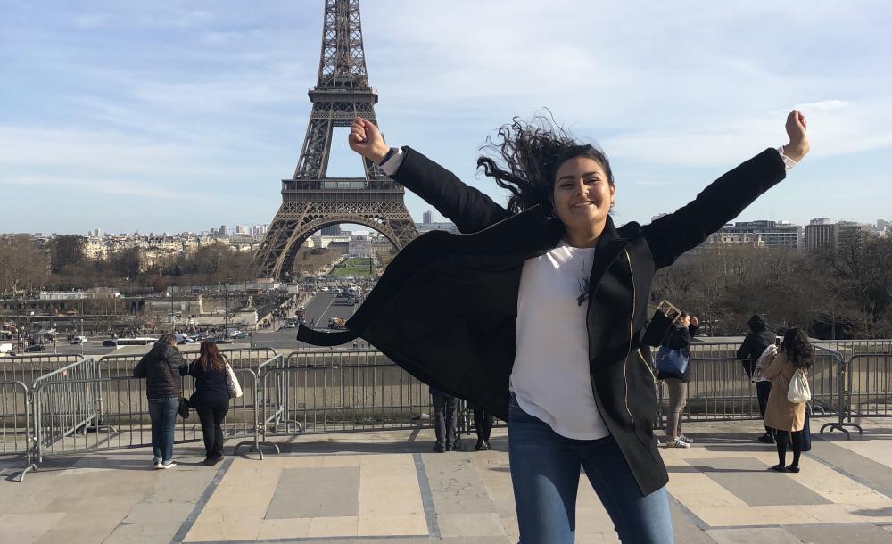 student jumping in front of the Eiffel Tower