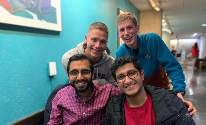 A group of four students smiling together