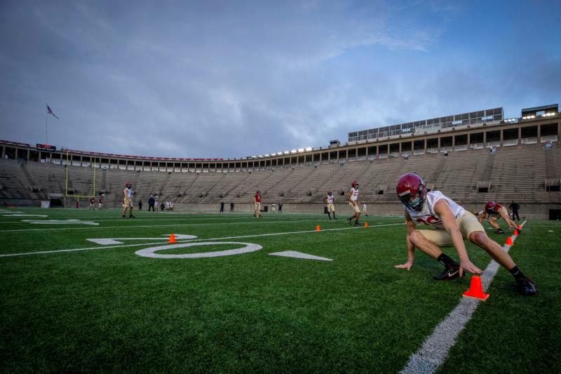 Defensive back Garrett Sharp '24 does an end-of-practice drill with his teammates at sunup in Harvard Stadium.