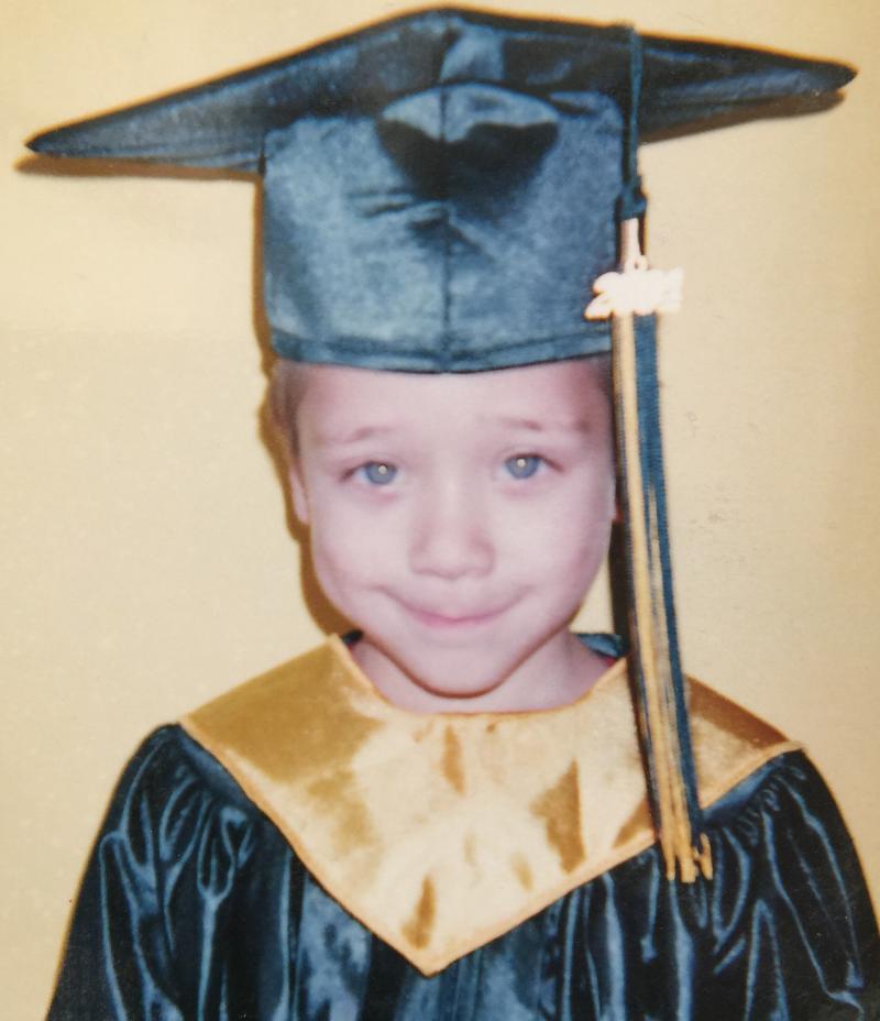 Young child posing for Kindergarten graduation