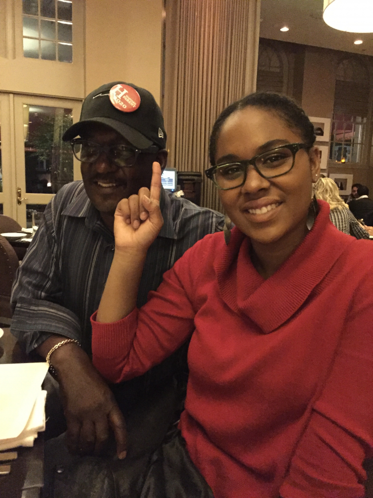 Student with her father who wears a Harvard Parent 2020 pin