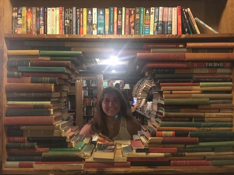 a student and bookshelves in bookstore