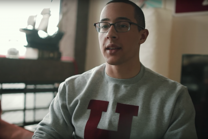 Student wearing Harvard sweatshirt talking
