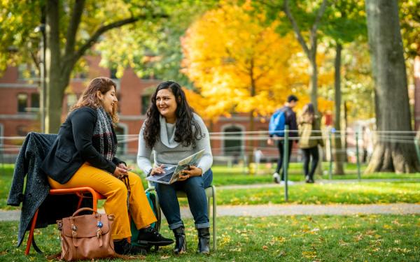 Two Students Sitting in Harvard Yard in the Fall