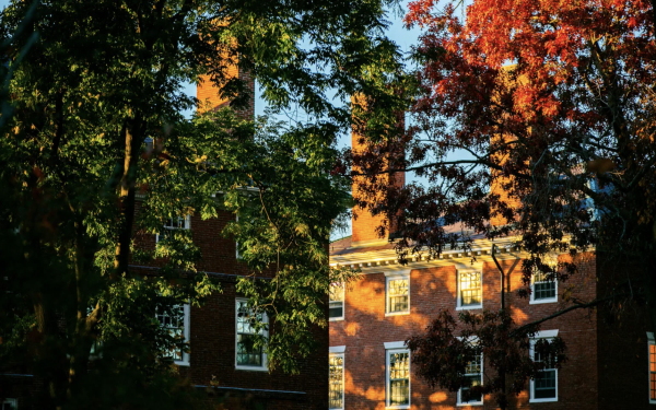 Brick building amidst fall colored trees 