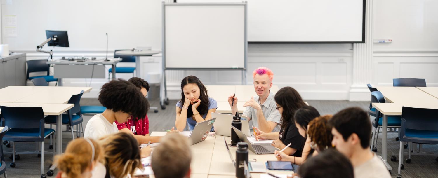 Students sit around a classroom with a professor