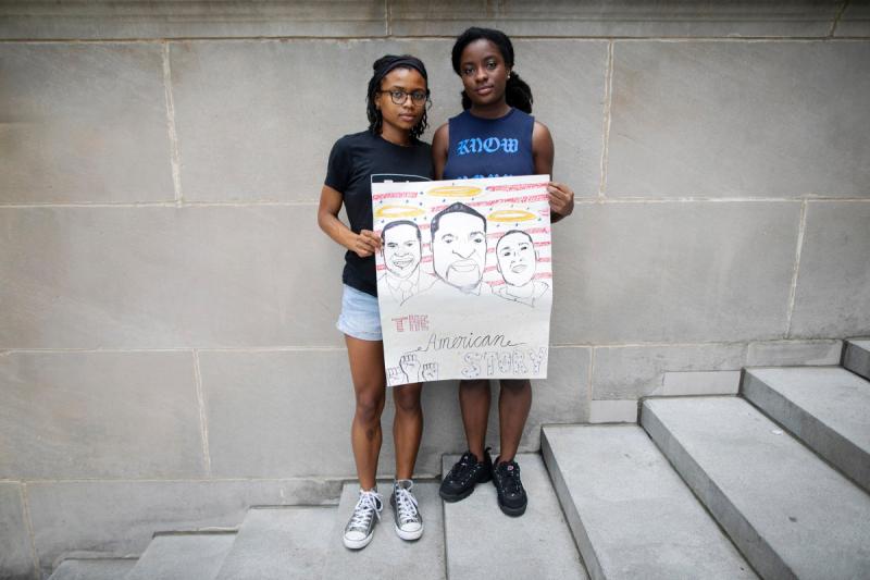 Sisters Cierra Brown ‘23 (left) and Kaelyn Brown '21 hold a sign they made for protests.
