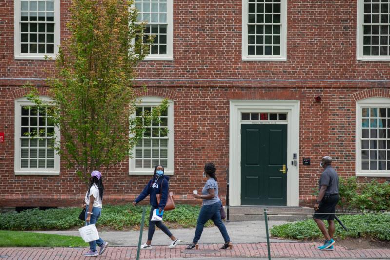 Lara Dada &#039;24 (second from left) walks with her family past Massachusetts Hall.