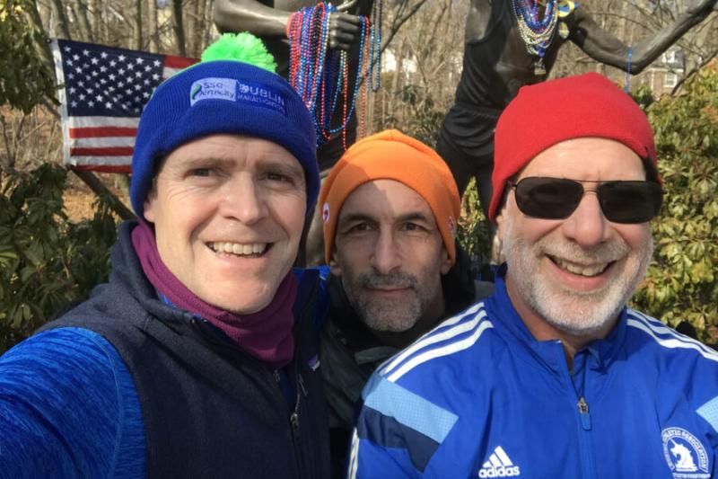 Taking a break during a Sunday run last February, Bob Manson, M.P.A. ’04, (left) poses with Daniel Lieberman ’86 (right) and a fellow runner in Newton at Heartbreak Hill, along the Boston Marathon course.