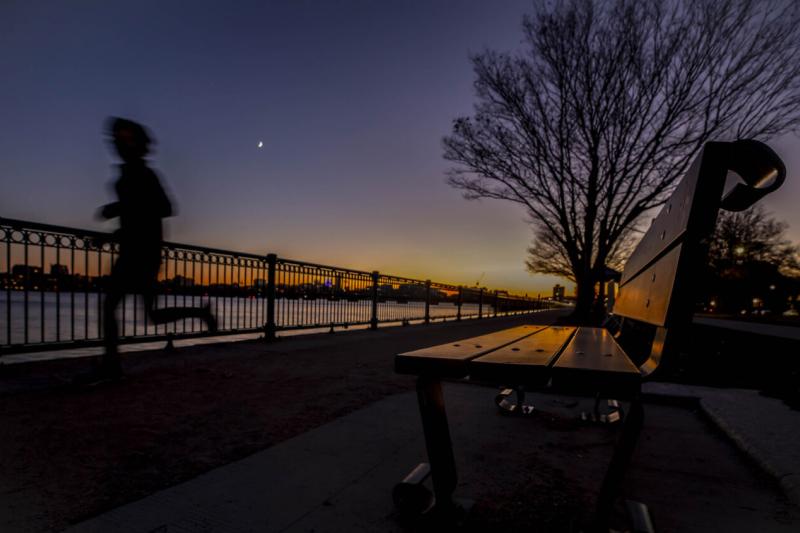 A runner passes the banks of the Charles River near MIT.