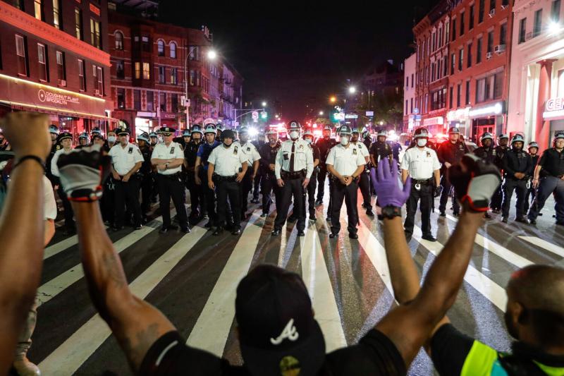 Protesters take a knee in front of New York City police officers during a solidarity rally for George Floyd, June 4, 2020.