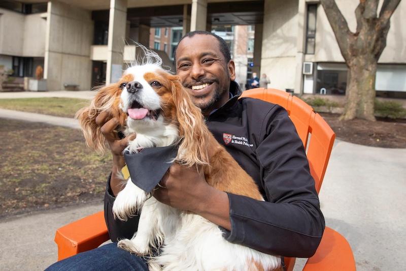 Anas El Turabi, a scholar in residence at Mather, holds his cavalier King Charles spaniel Cori, the House's informal mascot, greeter, and morale booster.