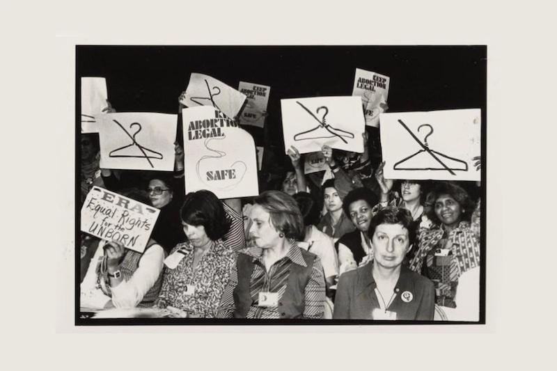 At the International Women's Year conference in Houston in 1977, attendees hold clashing signs on abortion rights.