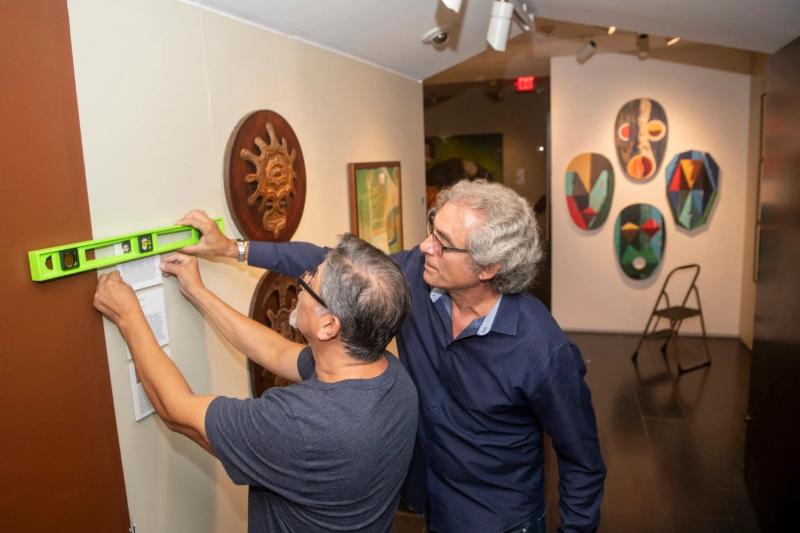Pablo Gonzalez (left) and Alejandro de la Fuente install “El Pasado Mío / My Own Past,” a new Afro-Cuban art exhibition at the Cooper Gallery.