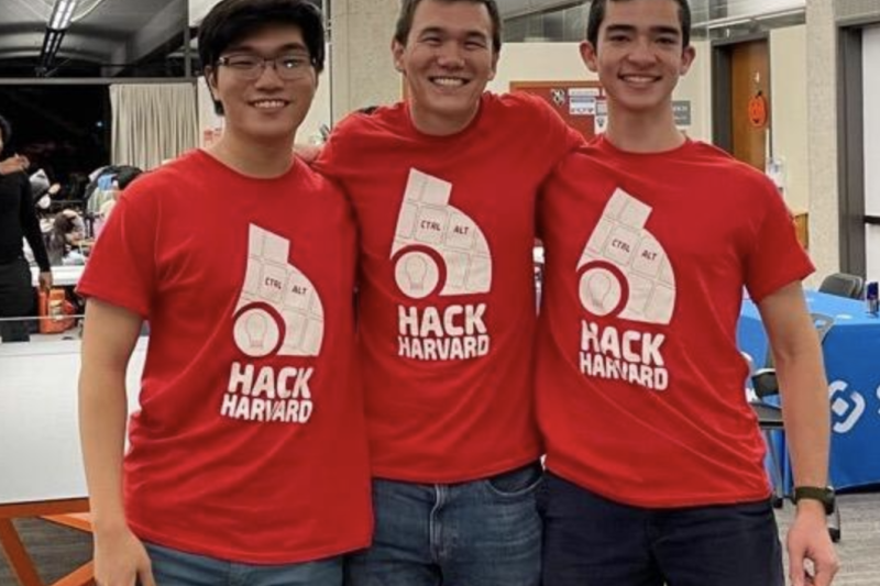 3 coders smiling and wearing shirts with the words, "Hack Harvard."