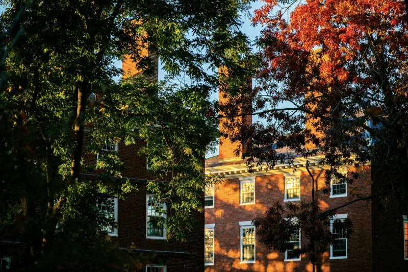 Brick building amidst fall colored trees 