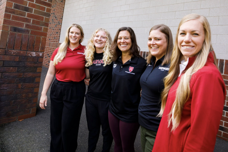5 women lined up next to each other in front of a building dressed in athletic gear
