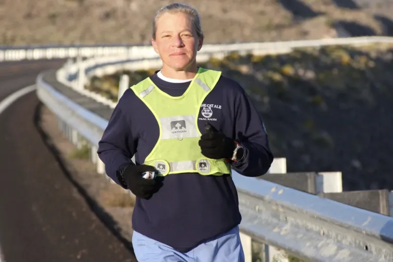 Physics Professor Jenny Hoffman running on the edge of a high way. 