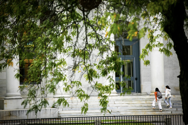 Students walk up set of stairs outside building 