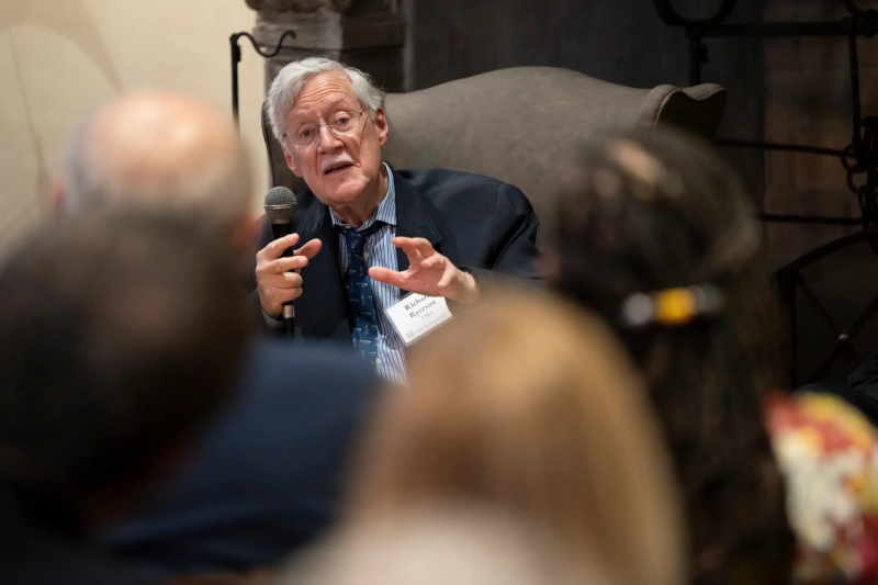 Historian Dick Ryerson sitting and speaking to a sitting crowd