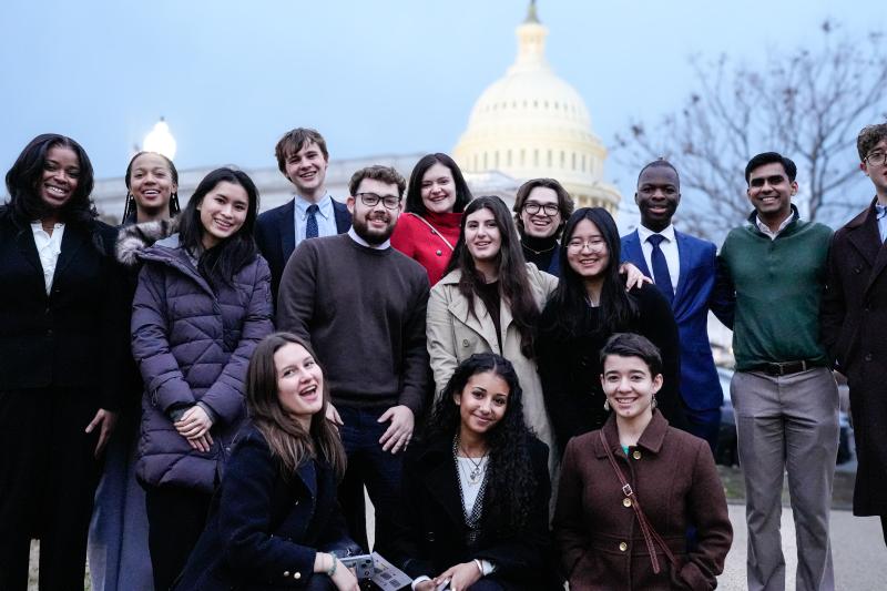 The students smiling as a group standing in front of the Capital building in Washington DC.