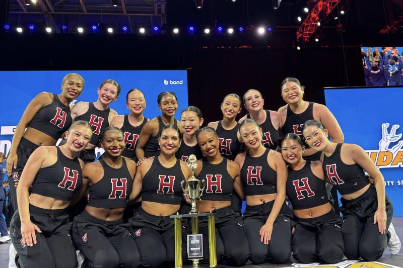 The Dance Team onstage crowded around their trophy.