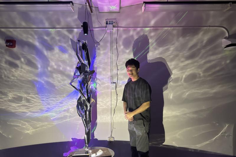 "The Meditation Room" co-designer Roger Zhu (Conflux Collective) standing next to a sculpture.