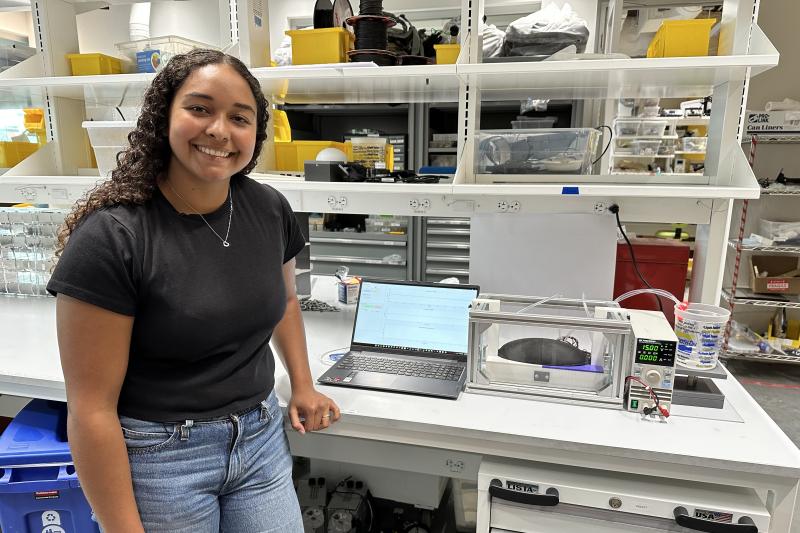 Senior Tiahna Padilla in the lab standing next to her thesis project.