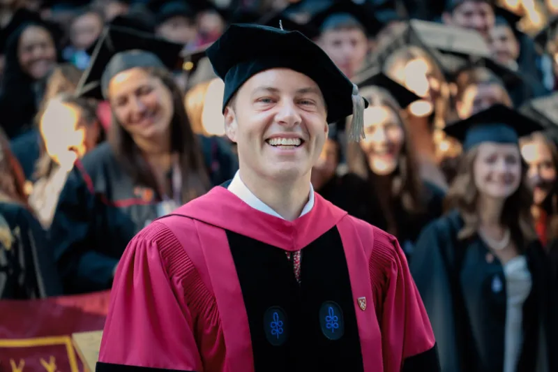 Danoff Dean of Harvard College, David Deming, smiling while wearing regalia at the 2026 Harvard Commencement.