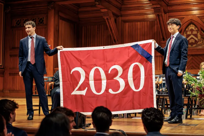 Zach Berg '28 and Daniel Zhao '28 holding up the Class of 2030 banner onstage.