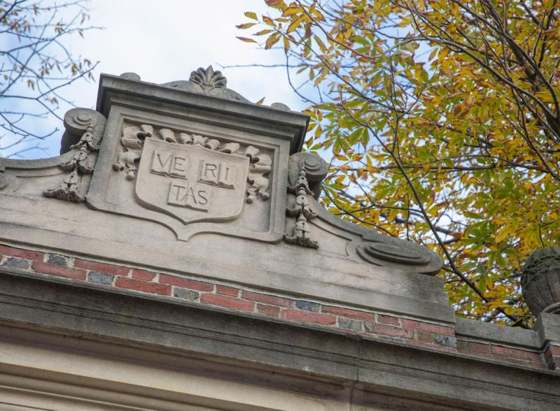 The Veritas shield engraved on one of the gates around Harvard Yard