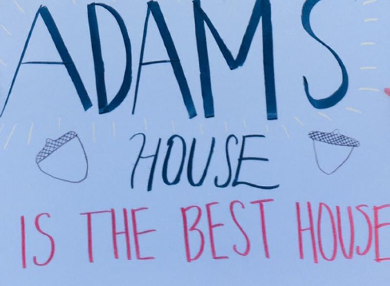 A picture of a white poster with "Adams House is the Best House" written on it.