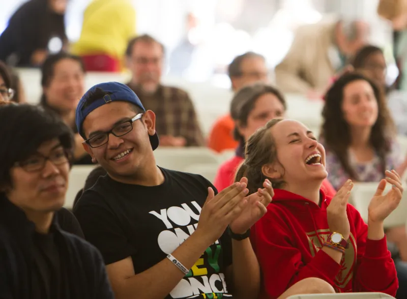Audience members clapping and smiling
