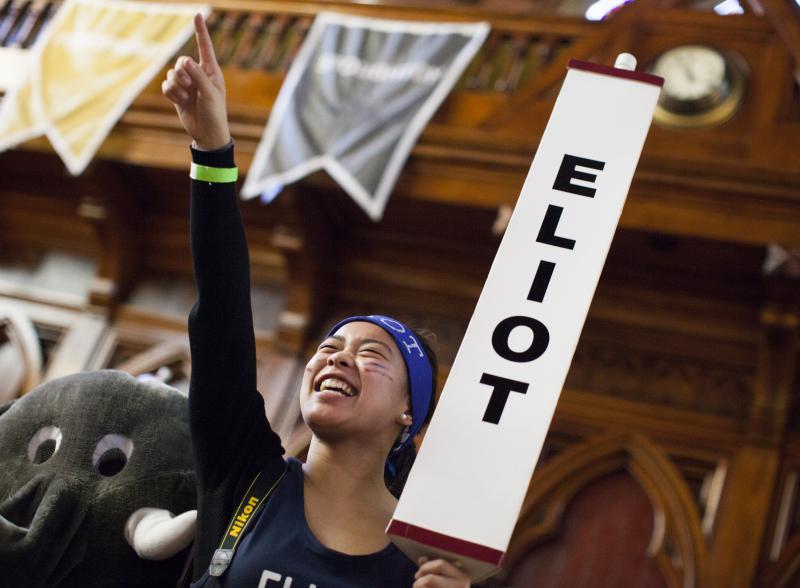 Student smiling and holding Eliot sign