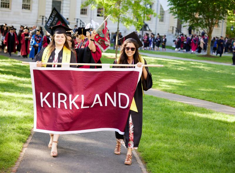 Hannah and a friend carry the Kirkland House banner at Commencement.