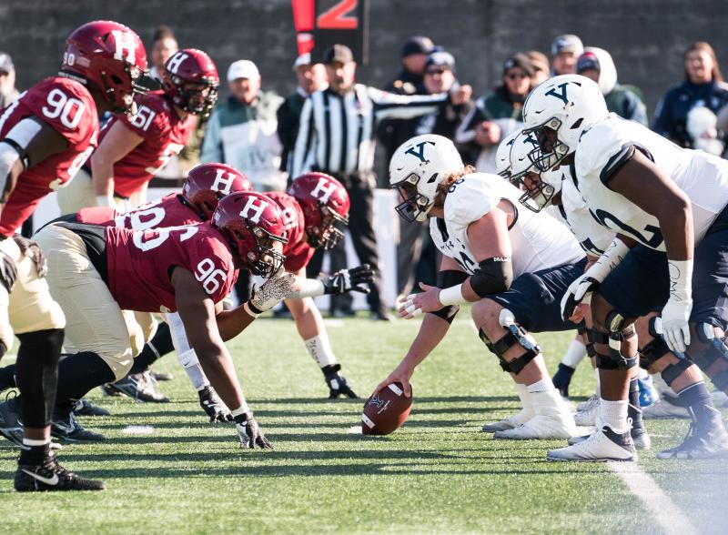 The Harvard and Yale Football teams face off.