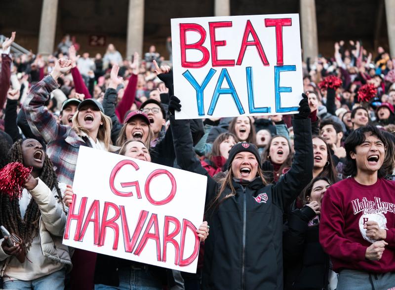 Students holding signs and cheering in a crowd. 