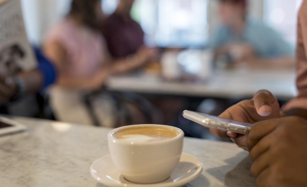 Student using phone at a coffee shop