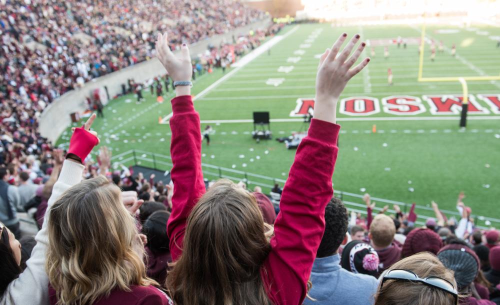 Students cheering at a Harvard football game