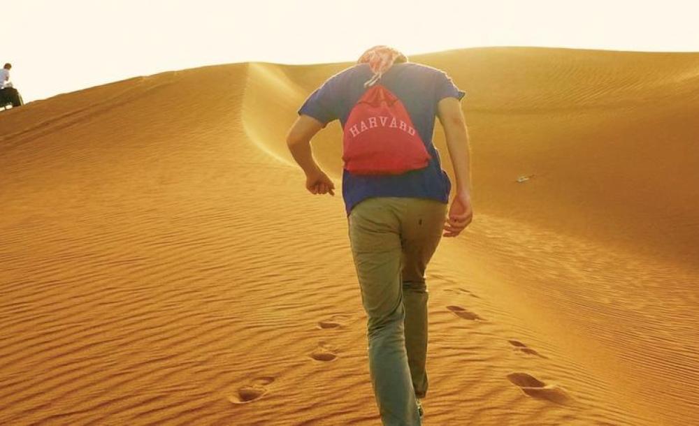 Student with Harvard backpack in desert