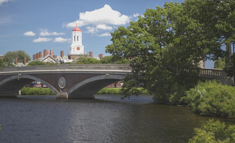 View of a bridge over the Charles river. Harvard campus can be seen in the background.