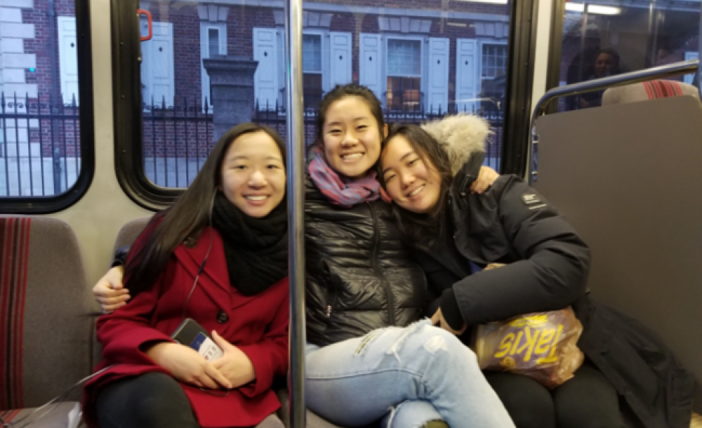 three students riding the subway