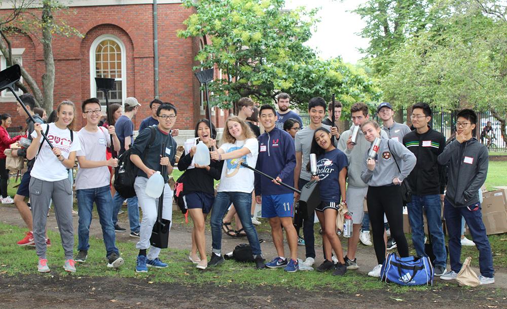 a group of stduents holding up cleaning items