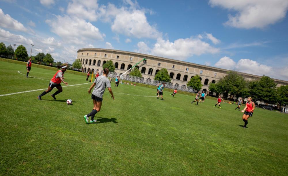 Members of the Harvard community playing soccer outside of Harvard Stadium.